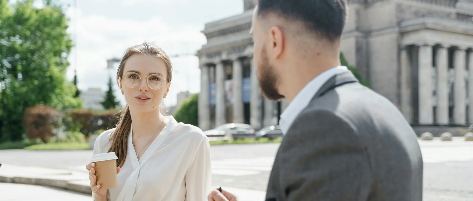 A man and woman in business casual having a relaxed lunch outdoors